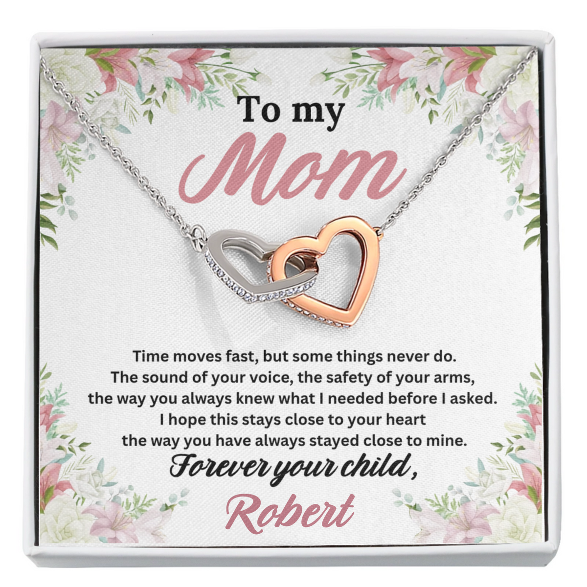 To My Mom Interlocking Hearts Necklace in polished stainless steel and rose gold finish laid flat on the personalized message card